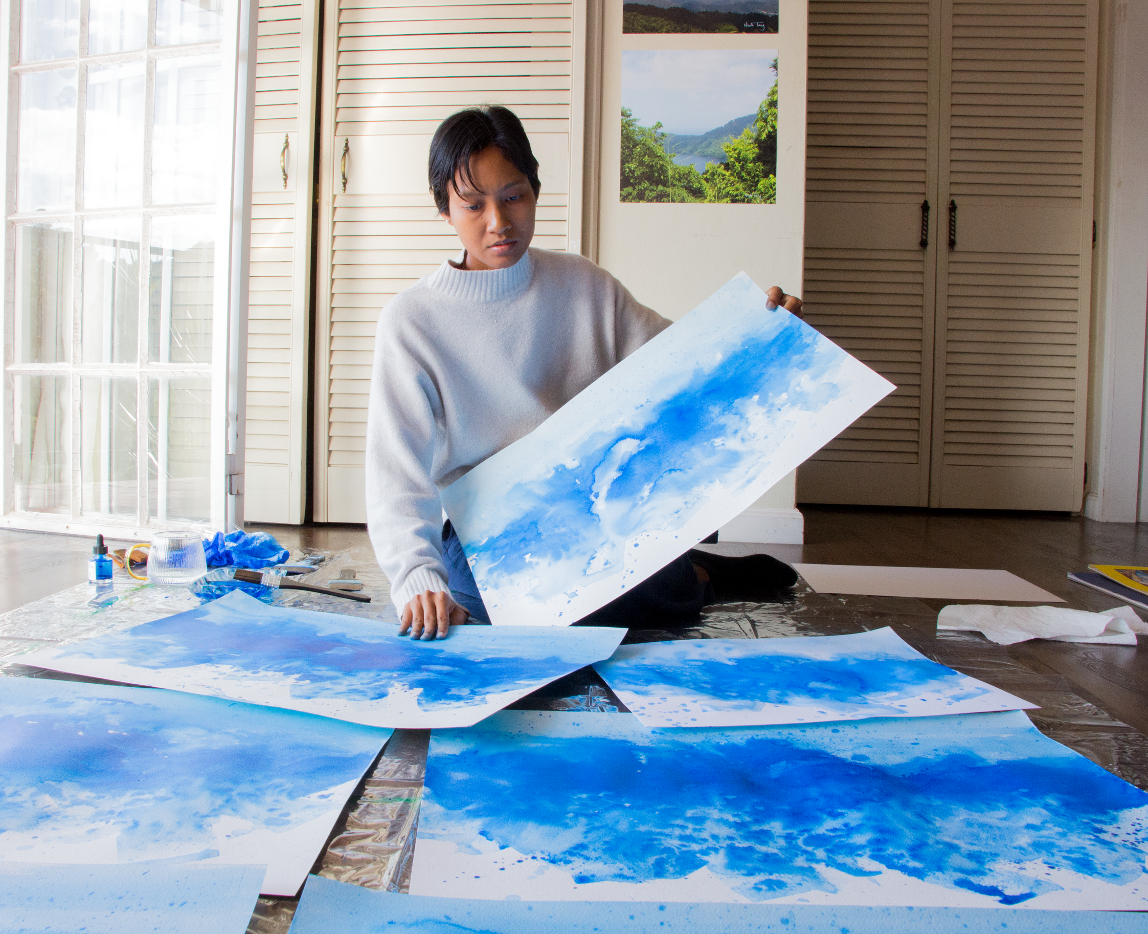 Nicole Tang in her art studio with her paintings